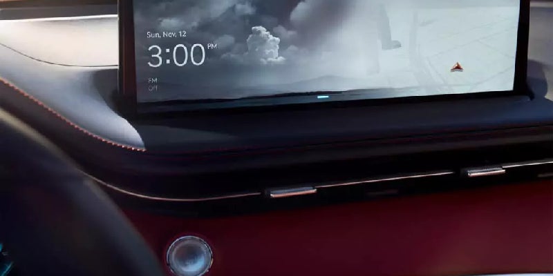 A close-up of a car's dashboard with a screen displaying time (3:00 PM), date (Sun, Nov 12), and cloud imagery.
